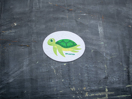 Plantish Sea Turtle - Pop up Sponge - small sea turtle pop up sponge on dark surface; plant-based