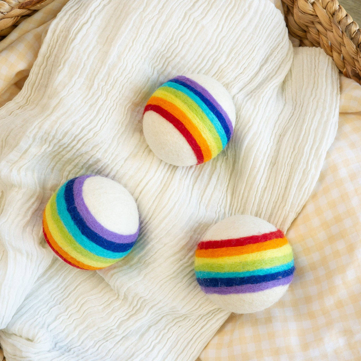 Friendsheep compostable rainbow wool dryer balls set of three: single rainbow wool dryer ball on folded white blanket