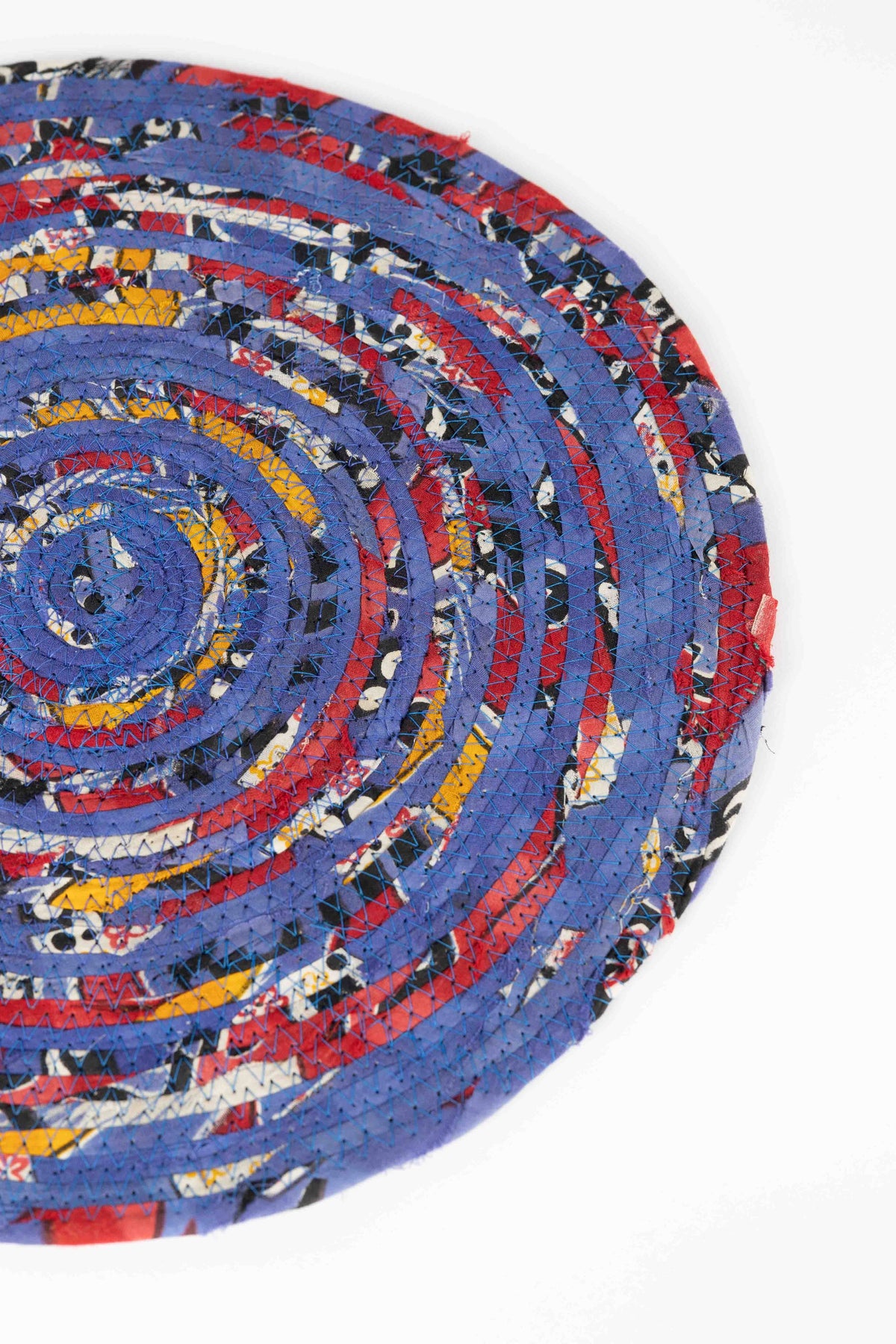 Ten Thousand Villages Recycled Sari Round Placemat: placemat staged in living space; recycled sari fabric