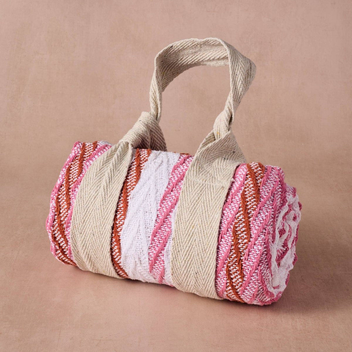 Ten Thousand Villages Garmee Upcycled Cotton Beach Blanket - Pink: blanket shown against a pale; recycled cotton fabric