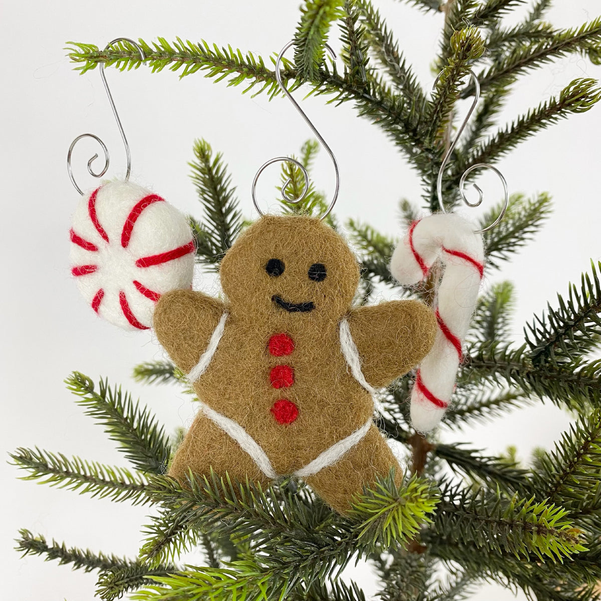 Sheep Farm Felt fair-trade felt Christmas ornament, felt gingerbread decoration hanging among branches of Christmas tree