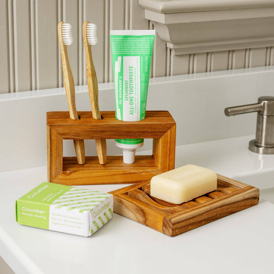 Ten Thousand Villages natural teak toothbrush holder, teak toothbrush holder with toothbrushes and soap near sink