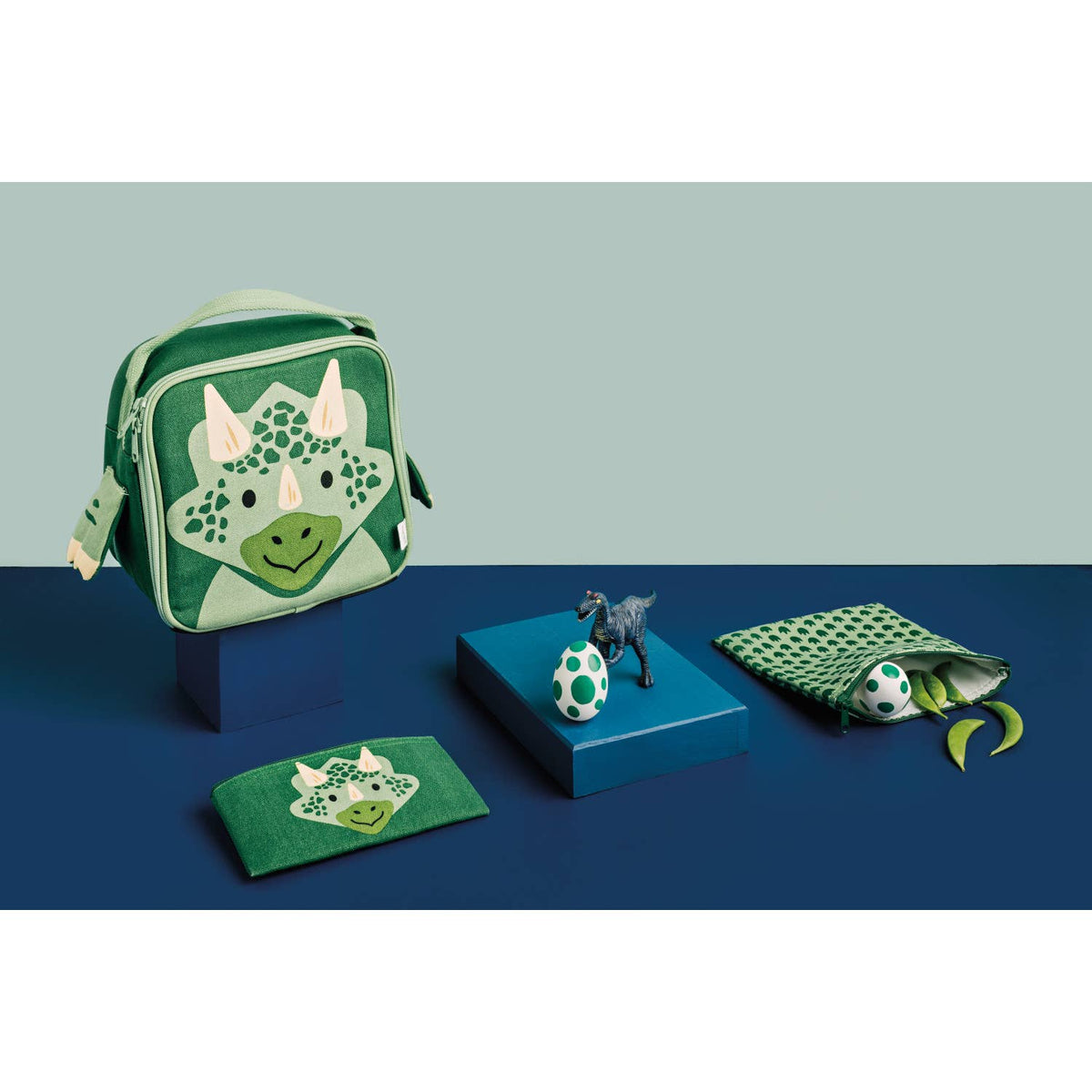 Danica Jubilee reusable dinosaur print snack bags, two printed snack pouches on blue surface