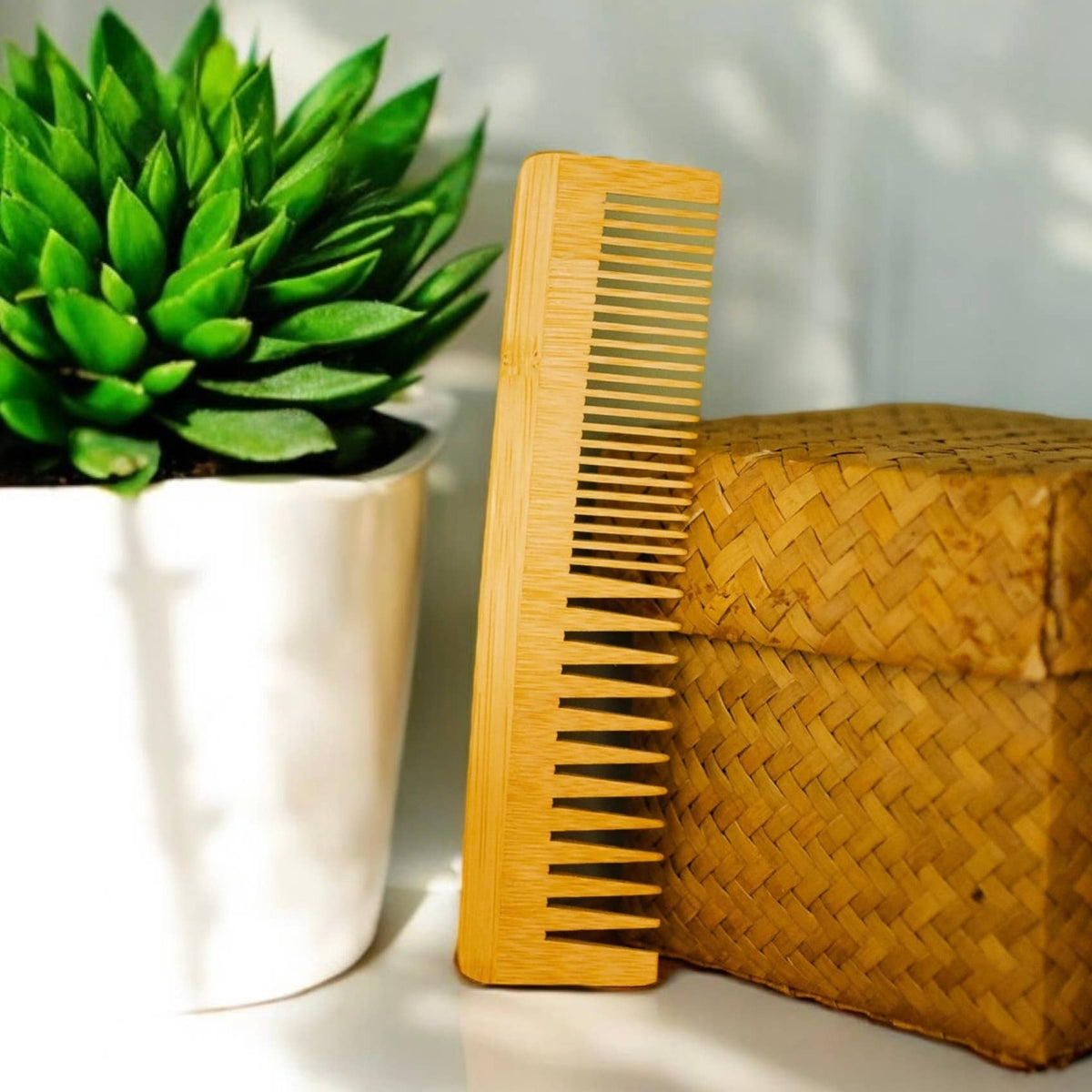 Bamboo Switch Bamboo Dual Comb - bamboo comb against plant and hand towel