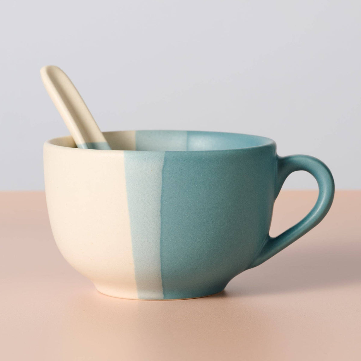 Ten Thousand Villages handmade Pheeka ceramic mug with matching spoon resting inside