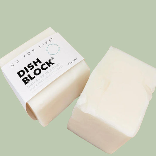 No Tox Life imperfect solid dishwashing soap block, white No Tox Life Dish Block soap bar beside recyclable paper wrap